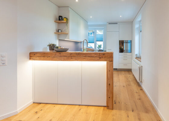 Die Barabtrennung gestaltet mit einem historischen Holzbalken