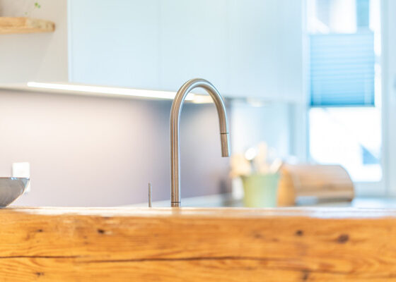 Moderne schlichte Armaturen in Kontrast zum antiken Holz