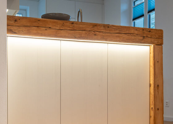 Moderne indirekte Beleuchtung kombiniert mit antikem Holzbalken